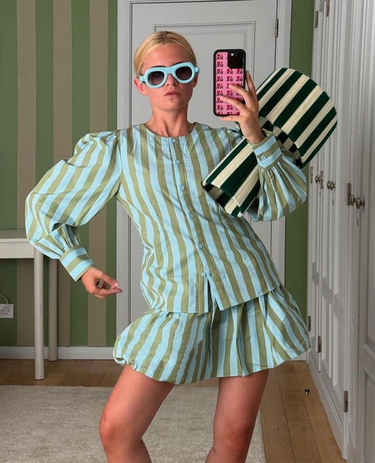 A creator wearing a green striped blouse and matching skirt