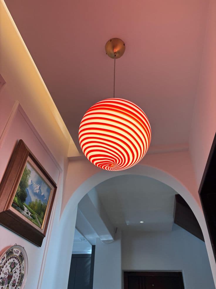 A hand-blown glass pendant lamp with red swirl stripes